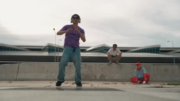 Egy csoport ázsiai break táncos utcai táncot ad elő multikulturális baráti támogatással és mozgó hip-hop zenével. Vonzó jóképű hipszter edzés b fiú tánc az utcán. Kültéri sport 2024. Élénk.. - Felvétel, videó