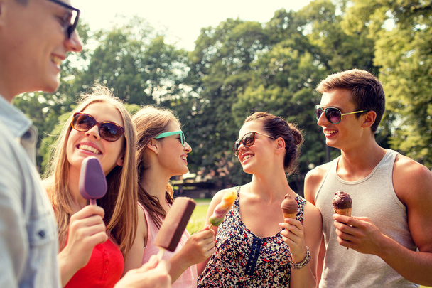 group of smiling friends with ice cream outdoors - Foto, Bild