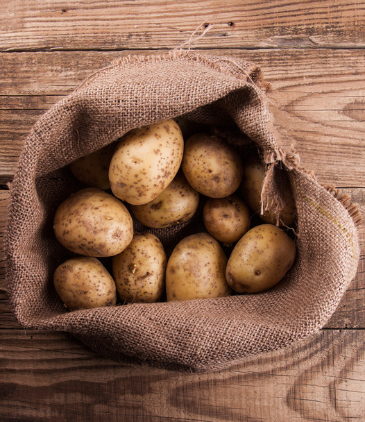 Harvest potatoes in burlap sack - Foto, afbeelding
