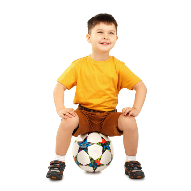 Figo bambino seduto su un pallone da calcio
 - Foto, immagini