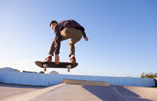 Sport, fitness en mens met skateboard, jump of hellingbaan actie in een skate park voor stunttraining. Vrijheid, adrenaline en gen z mannelijke schaatser met energie, lucht of vaardigheid praktijk, oefening of prestaties. - Foto, afbeelding