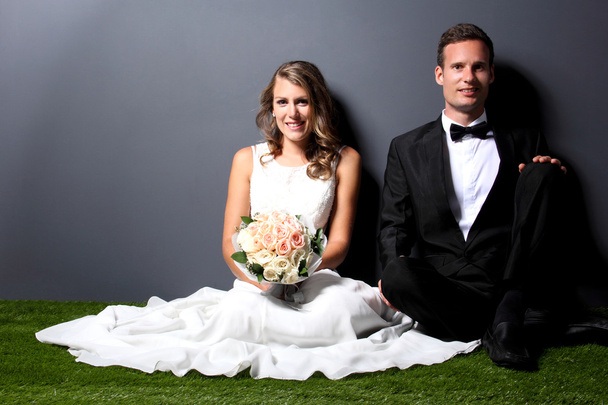 jeune couple nouvellement marié assis sur l'herbe
 - Photo, image