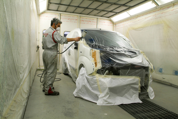 Worker painting a car on his garage - Foto, Imagen