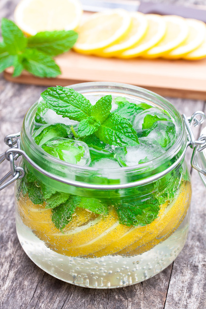 homemade fruit drink with lemon mint and ice on the table - Foto, Imagem