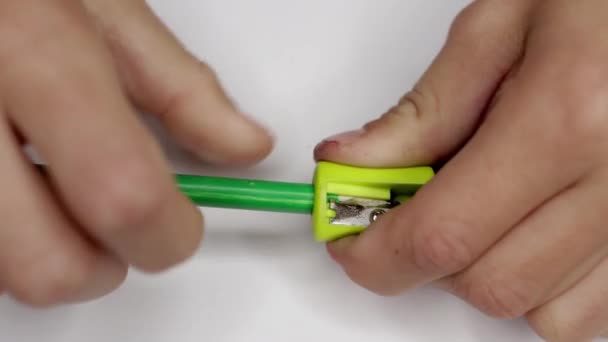 een jongen scherpt een potlood in zijn kunstruimte, close-up op zijn handen en gebruiksvoorwerpen. Hoge kwaliteit 4k beeldmateriaal - Video