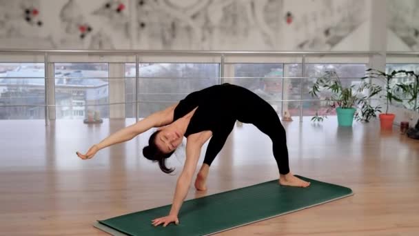 Жінка в фітнес-студії Йога позує на медитацію гармонії чакри. Босонога жінка виконує гнучкі вправи для психічного здоров'я та розслаблення. Спортивний тренер робить позу Асани наодинці в класі - Кадри, відео