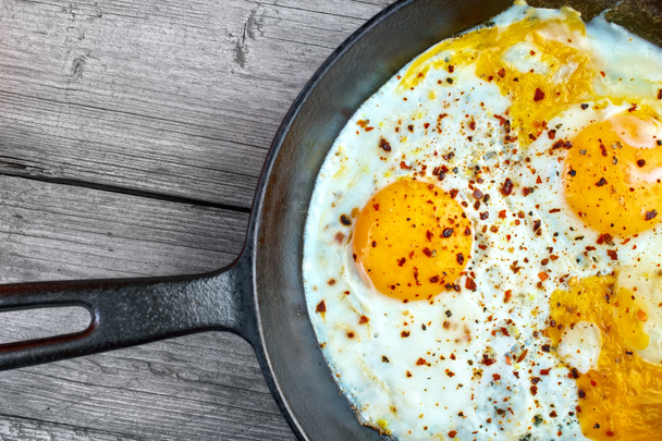 Τηγανιτά αυγά σε τηγάνι χυτοσιδήρου - Φωτογραφία, εικόνα