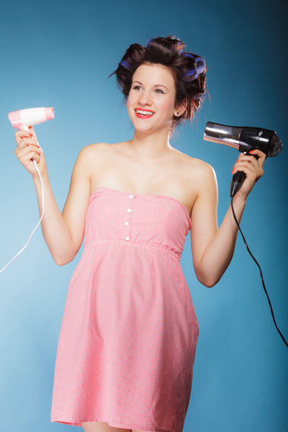 girl with curlers in hair holds hairdreyers - Φωτογραφία, εικόνα