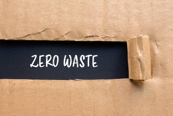 Zero odpadów zapisanych na pociętym tekturowym papierze z czarnym tłem - Zdjęcie, obraz