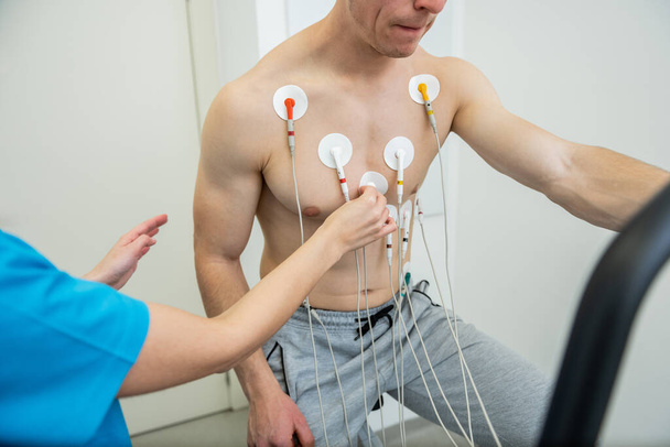 Пацієнт проходить серцевий тест з електродами, прикріпленими до грудей. - Фото, зображення