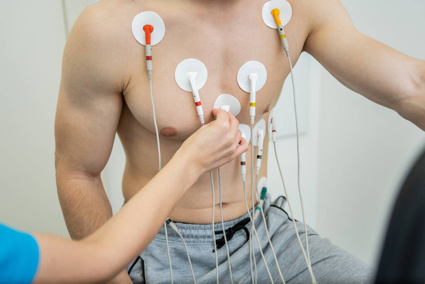 Paciente sometido a una prueba cardiaca con electrodos conectados al tórax. - Foto, Imagen