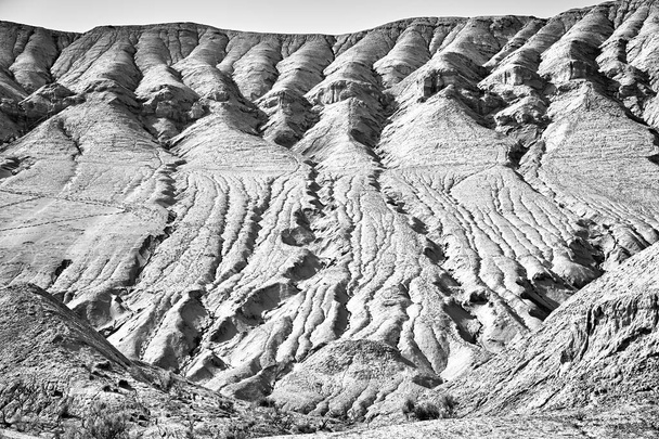 scenic view of a mountain with visible layers and traces of erosion in the Altyn Emel National Park, Kazakhstan. Monochrome photo - Photo, Image