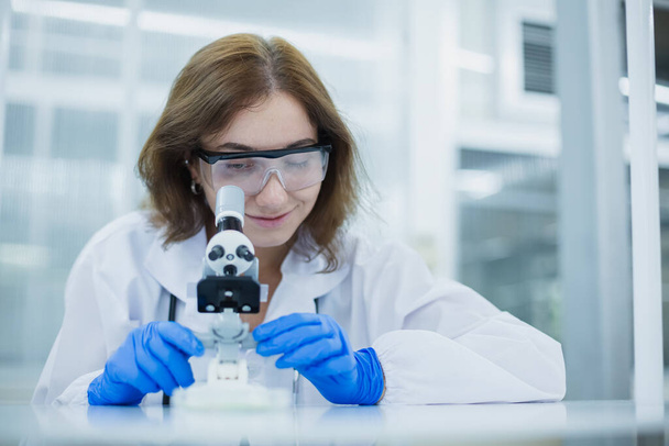 Bilim bölümü öğrencileri mikroskop araştırması için tıp bilimine bakıyorlar. Bilimsel kimya biyolojisini öğrenmek için tıbbi verileri analiz et. Laboratuvarda kadın bilim adamı. - Fotoğraf, Görsel