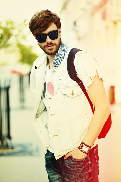 Funny smiling hipster handsome man guy in stylish cloth in the street in sunglasses - Фото, изображение