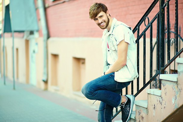 Funny smiling hipster handsome man guy in stylish cloth in the street in sunglasses - 写真・画像