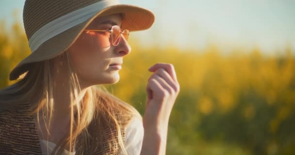 A captivating portrait of a woman strolling gracefully amidst a vibrant rapeseed field, evoking feelings of serenity and connection with nature - Footage, Video