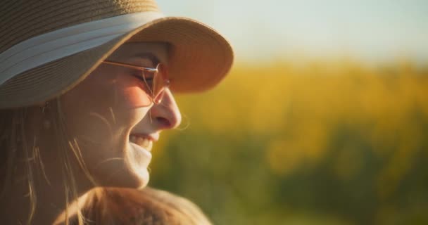 Un retrato cautivador de una mujer paseando con gracia en medio de un vibrante campo de colza, evocando sentimientos de serenidad y conexión con la naturaleza - Metraje, vídeo