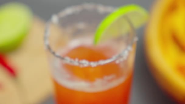 Michelada - Cóctel de inspiración mexicana con cerveza, jugo de lima, jugo de tomate y especias. Enfoque selectivo - Imágenes, Vídeo