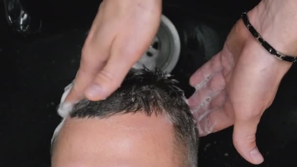 Κομμωτής δίνει χαλαρωτικό μασάζ στο κεφάλι πελάτη πλύσιμο μαλλιών στο κουρείο. Επαγγελματική φροντίδα του πελάτη hairstyle. Διαδικασία Spa - Πλάνα, βίντεο