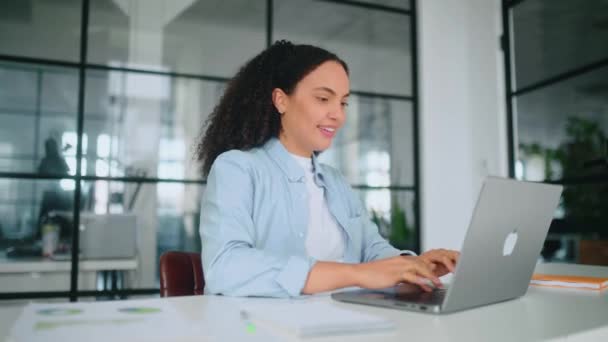 Rest during workday. Happy brazilian or hispanic woman, company employee, relaxing at a workplace, finish work on a laptop in the office, she put her hands behind her head and closed her eyes, smiling - Footage, Video