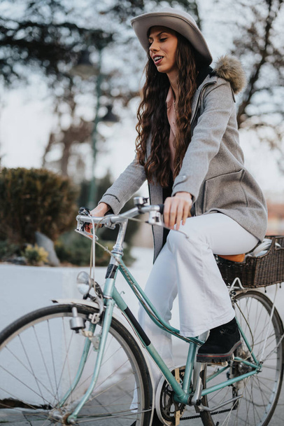 レジャー休憩中に都会の公園で自転車でスタイリッシュな服を着たプロのビジネスレディ. - 写真・画像