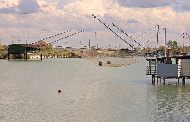 Cabañas de pesca del mar Adriático llamadas Bilancioni o Padelloni en lengua italiana construidas sobre pilotes con redes de pesca - Foto, imagen