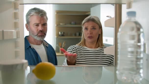 大人の中年家族 カップル 女性 男性 成熟した 夫 妻 POV 視点 内側 冷蔵庫 開いた 空の冷蔵庫 水 と レモン 紛争 怒り 論争 問題 論争 - 映像、動画
