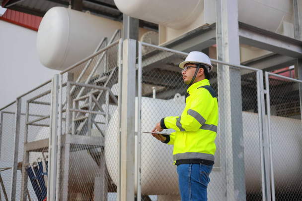 Portret van een beroepsingenieur die de werkplek controleert om vloeibaar helium in de industrie te houden. - Foto, afbeelding