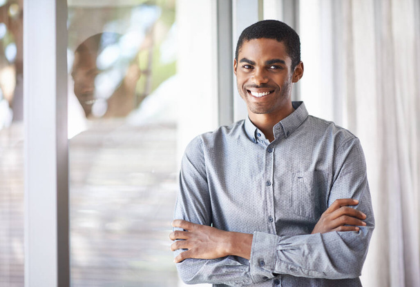 Счастливый черный мужчина, портрет и окно со скрещенными руками за карьерные амбиции, работу или творческий стартап в офисе. Африканский мужчина или работник улыбается с уверенностью в опыте или позитивном мышлении. - Фото, изображение