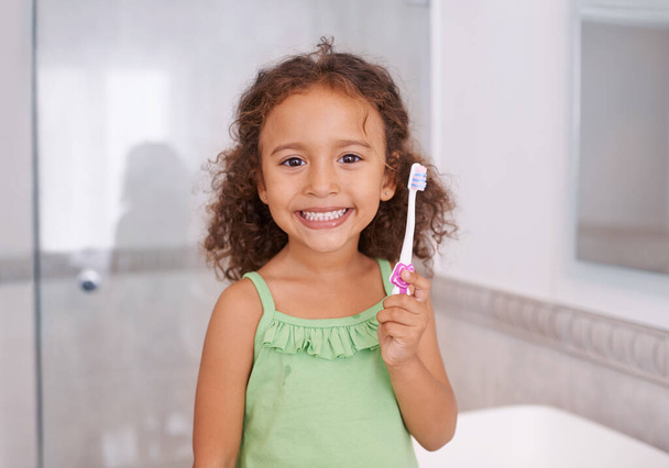 Portre, gülümseme ve dişlerini diş sağlığı için banyoda fırçalayan bir kız. Ağız temizliği, çocuk gelişimi ya da öğrenim için diş fırçası olan bir evde mutlu, yüzü ve çocuğu.. - Fotoğraf, Görsel