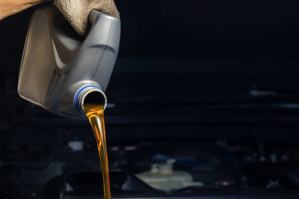 Gießen Sie Motoröl aus der Schmiermittelflasche. Motor Hintergrund, Ölwechsel Shop Motor Service Industrie - Foto, Bild