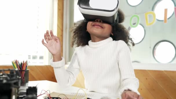 Meta-evrende öğrenmek için VR kulaklık takan yaratıcı kız. Komik çocuk yapay zeka kulaklığı takıp BTMM teknoloji sınıfında sanal dünya programına katılmayı seviyor. Yenilik. Gelecekteki yaşam tarzı. Etkinlik. - Video, Çekim