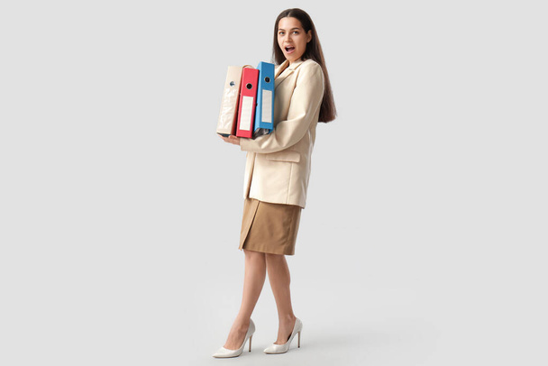 Szokująca bizneswoman z folderami na białym tle - Zdjęcie, obraz
