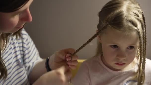 Una donna intreccia i capelli di sua figlia - Filmati, video