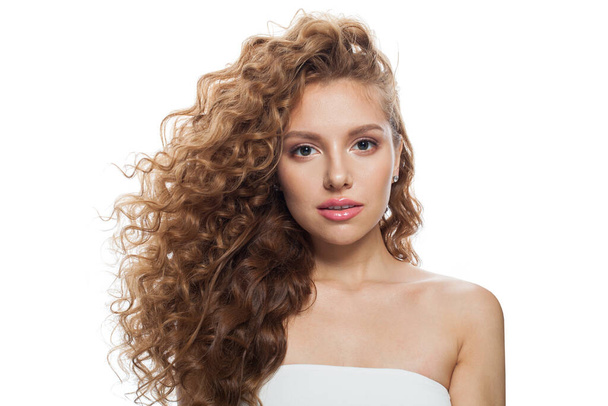 Stijlvolle jonge vrouw met natuurlijke make-up, heldere frisse huid en golvend kapsel op witte achtergrond - Foto, afbeelding