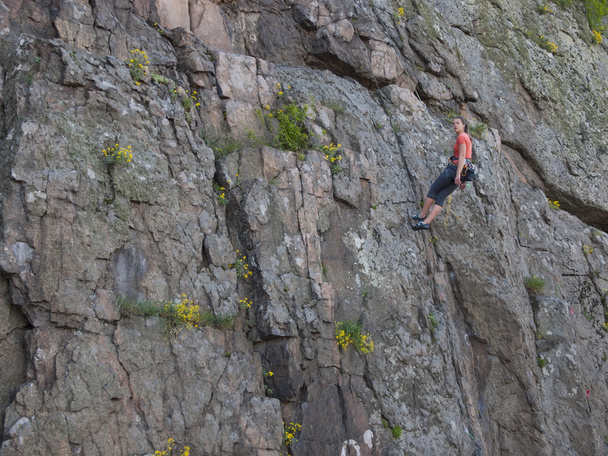 Nuori tyttö kiipeilee kallioilla.
. - Valokuva, kuva