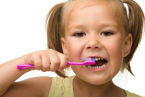 Little girl is cleaning teeth using toothbrush - Fotó, kép