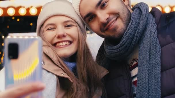 Nuori pari ottaa selfie joulumarkkinoilla yöllä - Materiaali, video