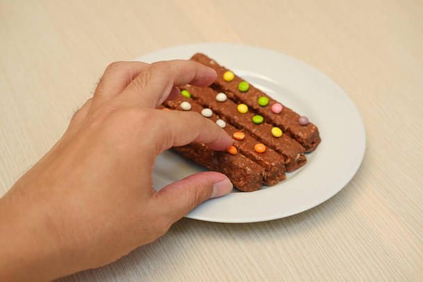 Csokis sütik színes cukorkákkal, fehér tányéron. - Fotó, kép