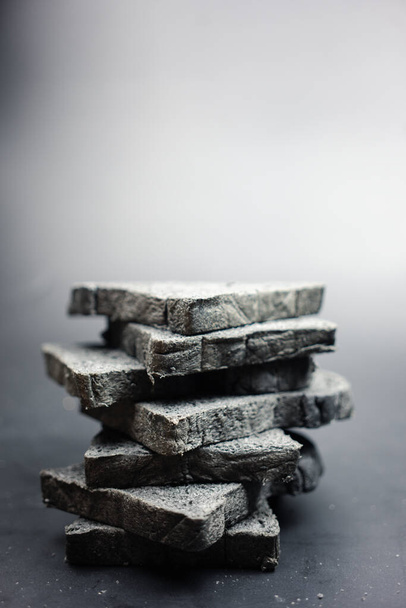Organic black charcoal bread stacks. Close up - Photo, Image