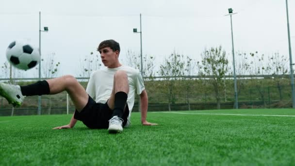 Nuori teini jalkapallo pelaaja tekee Freestyle istuu jalkapallokenttä. - Materiaali, video