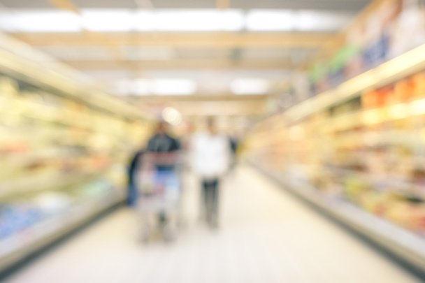 経済危機の期間中に消費者の一般的なスーパー マーケットの車線概念の多重背景をぼかした写真空の回廊の食料品商業の中心地での人々 のいくつかの中立的なぼかし - 写真・画像