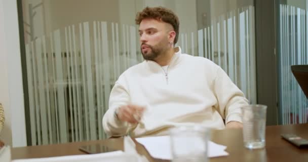 Young, male, business worker engaging in a discussion during a team meeting, explaining and sharing opinions in a modern office. - Footage, Video