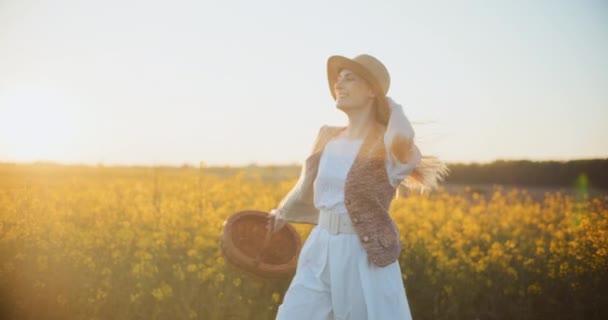 Experience the joy of success as a smiling woman runs through a lush, yellow oilseed canola field, radiating positivity and happiness in this exhilarating scene - Footage, Video