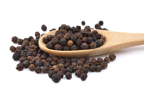 Black pepper in wooden spoon on white background. - Photo, Image