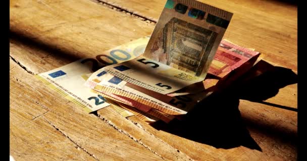 Le banconote in euro su un tavolo di legno contano. Le mani contano banconote in euro su un tavolo di legno in una striscia di luce.Reddito delle donne nei paesi europei. Al rallentatore. 4k filmati - Filmati, video