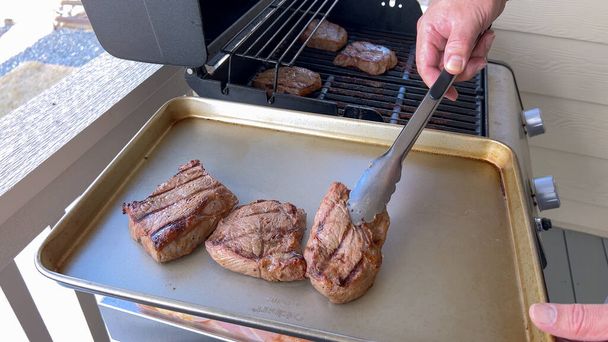グリルマーク付きのいくつかの厚いステーキは,屋外グリルで完璧に調理し,晴れたバーベキューの日の本質をキャプチャ. - 写真・画像
