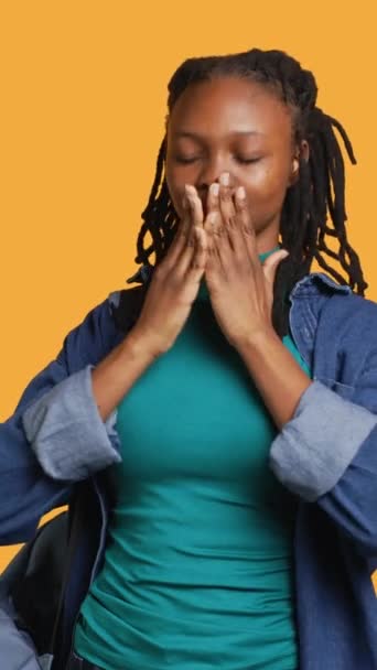 Vertical video African american woman covering eyes, ears and mouth with hands, imitating the three wise monkeys. Girl doing do not see, do not hear and do not speak gesturing concept, studio - Footage, Video
