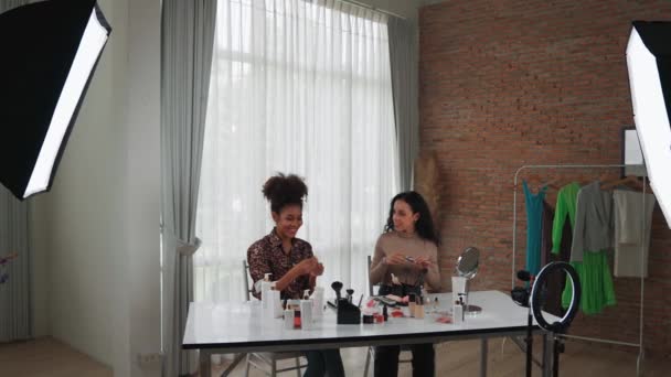 Zwei Influencerinnen drehen Live-Streaming-Video-Review Make-up entscheidenden sozialen Medien oder Blog. Glückliches junges Mädchen mit Kosmetikstudio-Beleuchtung für Marketing-Aufnahmen, die online ausgestrahlt werden. - Filmmaterial, Video