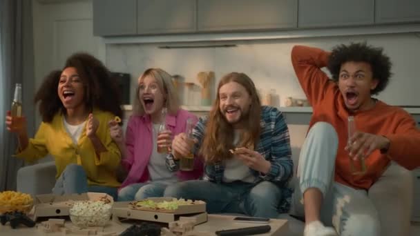 Multiracionális barátok multietnikus emberek otthon kanapén pizza és sör együtt afro-amerikai férfiak fiúk haverok kaukázusi nők barátság néz TV-támogatás sport játék érzelmi kiabálás - Felvétel, videó